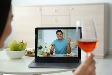 Photo of Friends drinking wine while communicating through online video conference at home. Social distancing during coronavirus pandemic