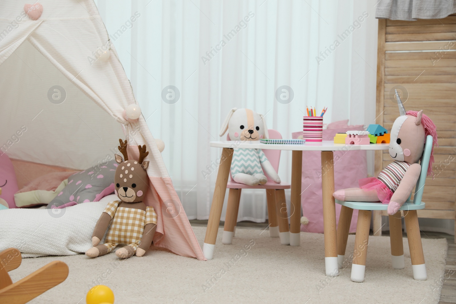 Photo of Cute child's room interior with toys and play tent