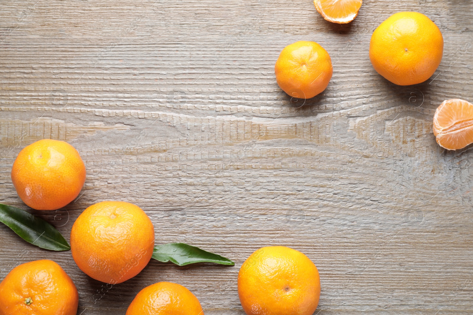 Photo of Fresh ripe tangerines on wooden table, flat lay. Space for text