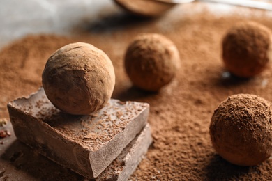 Photo of Sweet raw chocolate truffles powdered with cocoa on table