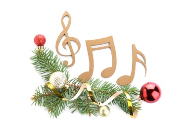 Fir tree branches with wooden music notes and Christmas decor on white background, top view