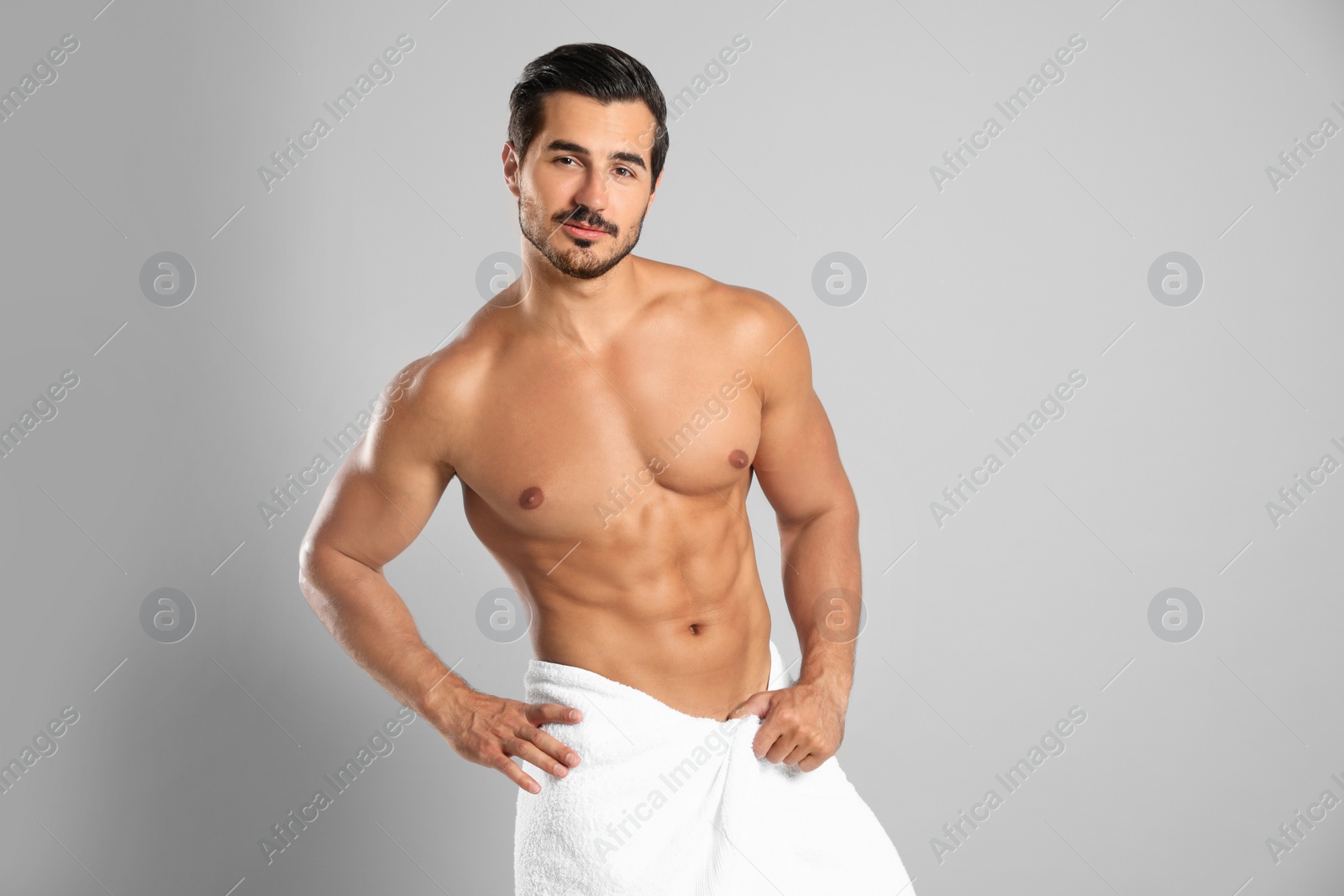 Photo of Young man with slim body on grey background