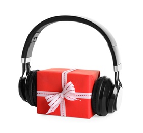 Photo of Gift box with headphones isolated on white. Christmas music concept
