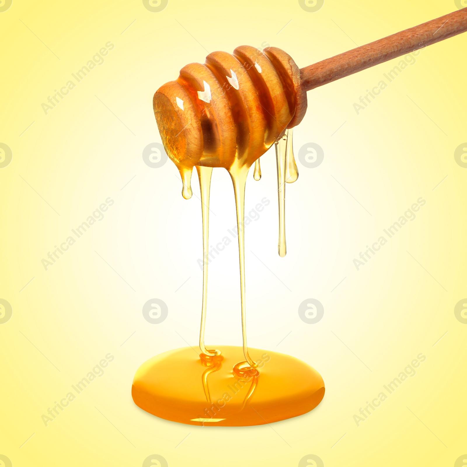 Image of Natural honey dripping from dipper on yellow background