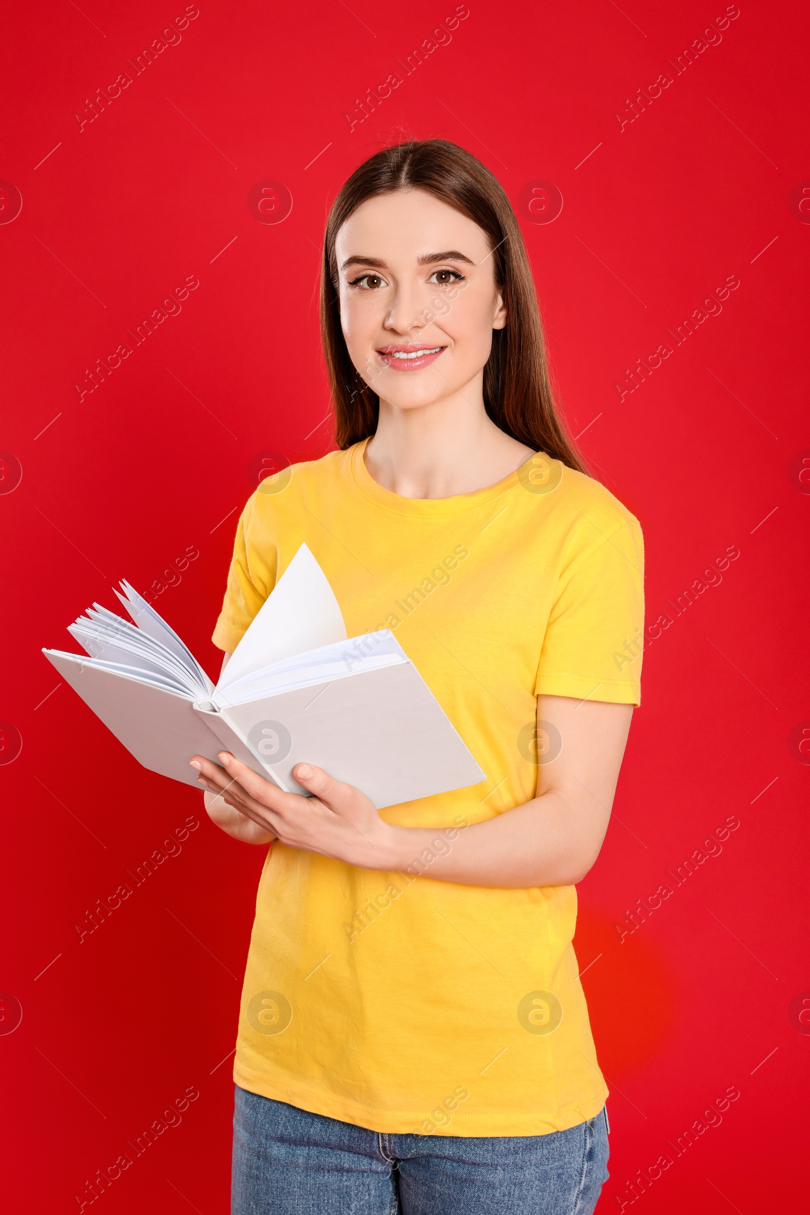 Photo of Young woman reading book on color background