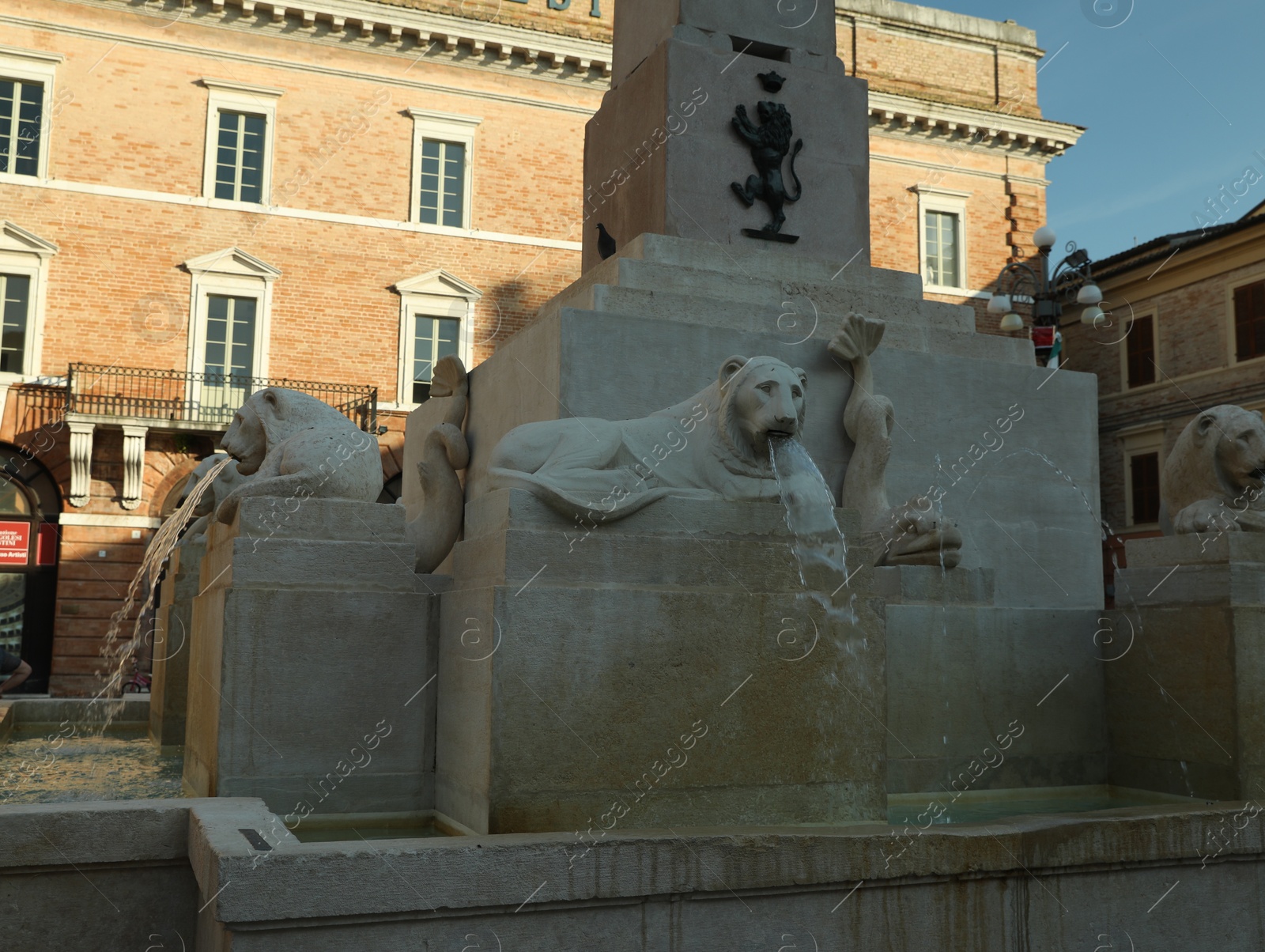 Photo of JESI, ITALY - MAY 17, 2022: Beautiful fountain of stone lions around obelisk on spring day