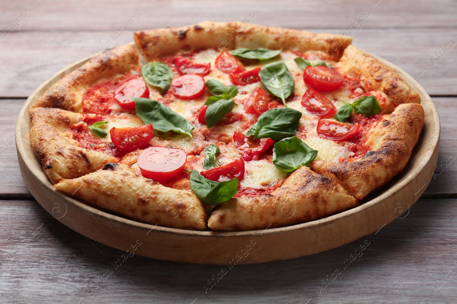 Photo of Delicious Margherita pizza on wooden table, closeup