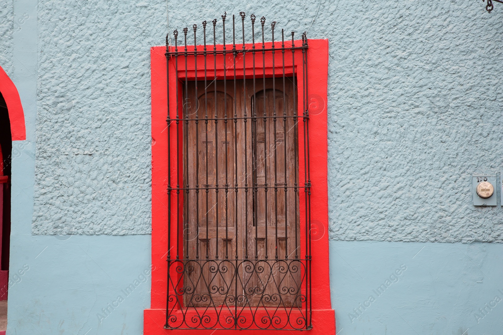 Photo of Light blue building with beautiful window and steel grilles