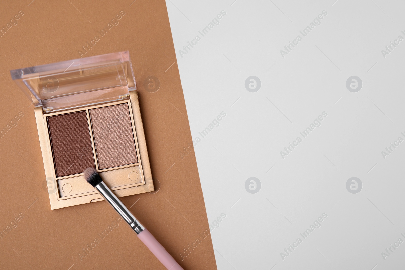 Photo of Eye shadow palette and professional makeup brush on colorful background, top view. Space for text