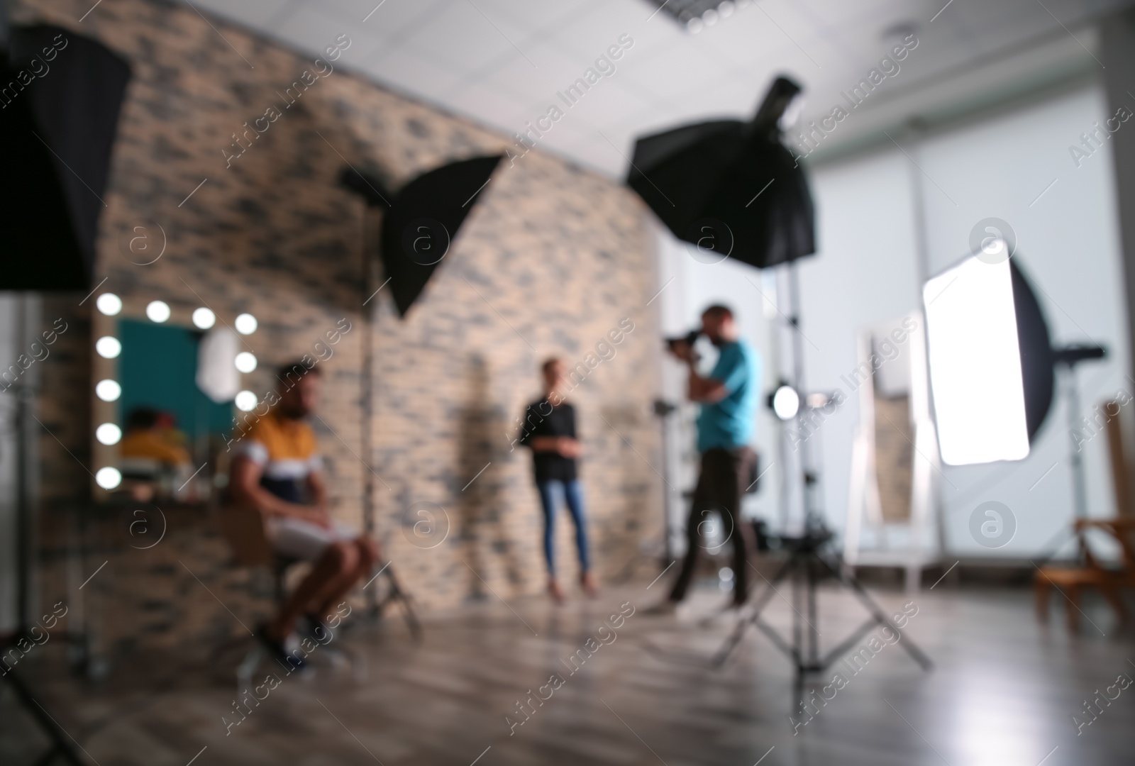 Photo of Blurred view of professional team working with model in photo studio