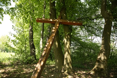 Wooden cross near trees in park outdoors