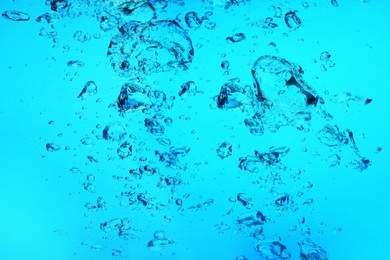 Image of Many air bubbles in water on light blue background