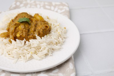 Photo of Delicious chicken curry with rice on white tiled table, closeup