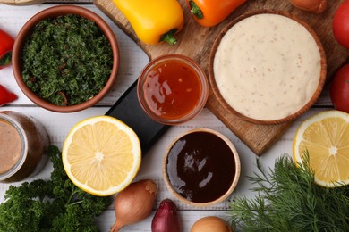 Photo of Different fresh marinades and ingredients on white wooden table, flat lay