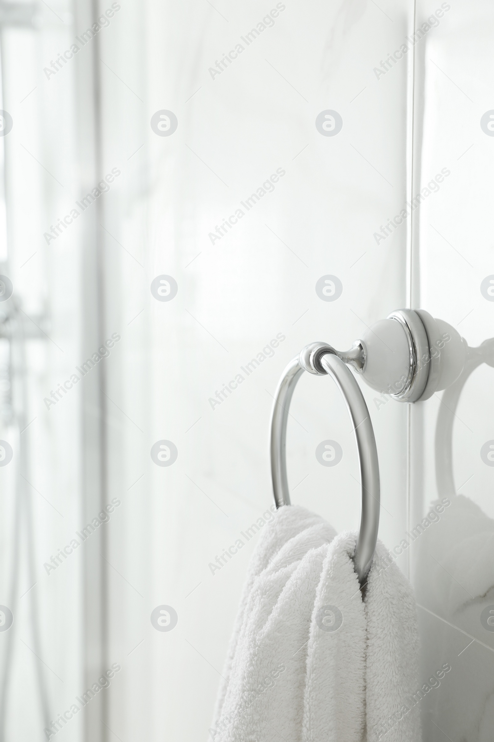 Photo of Holder with clean towel on light wall in bathroom. Space for text