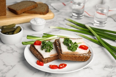 Photo of Composition with plate of pork fatback sandwiches on marble table