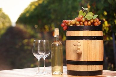 Photo of Composition with wine and ripe grapes on table outdoors. Space for text