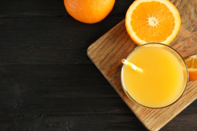 Photo of Glass with orange juice and fresh fruit on wooden background, top view with space for text