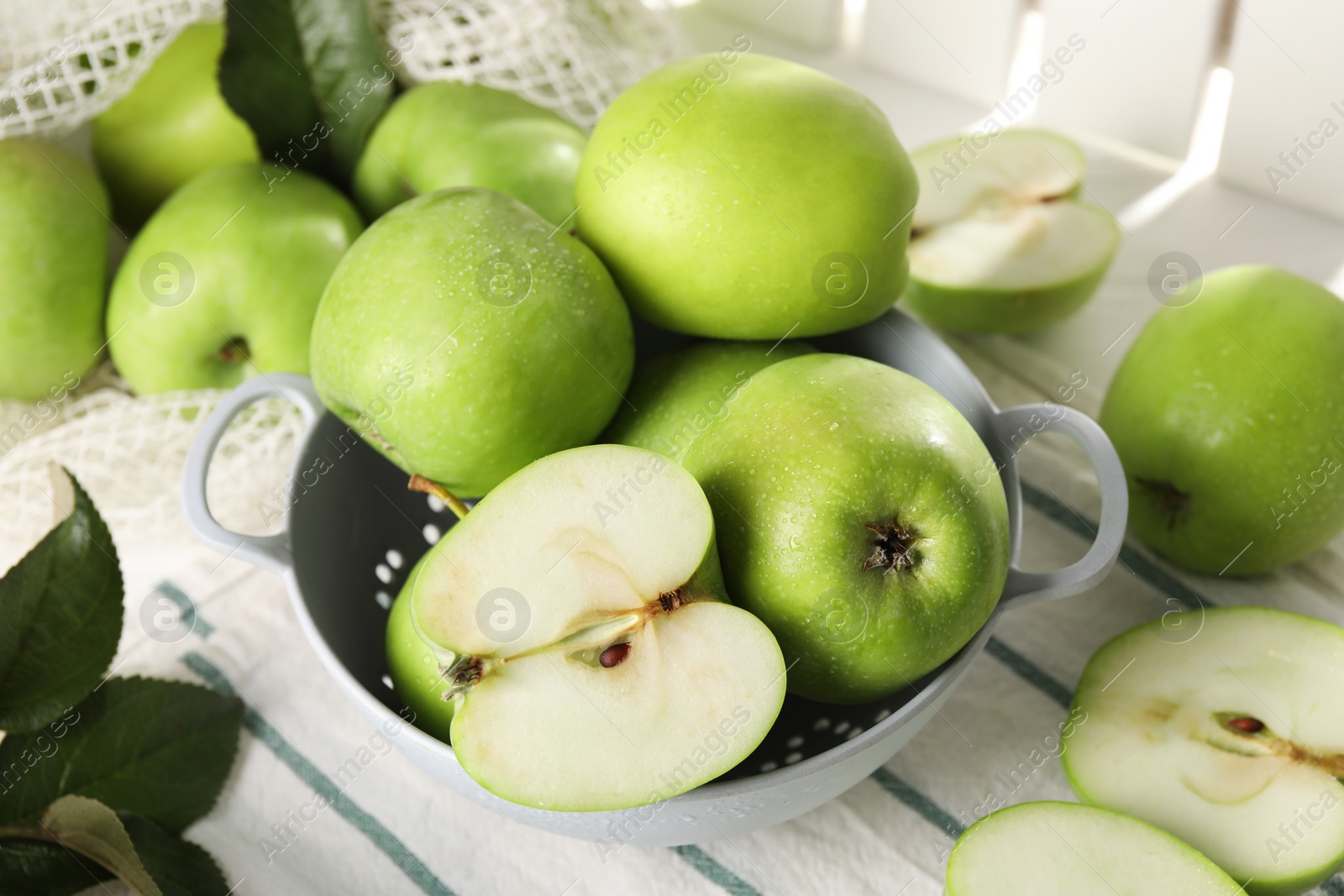 Photo of Fresh green apples with water drops on white table, closeup