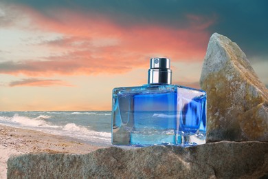 Bottle of aquatic perfume on rock near ocean. Fresh sea breeze scent