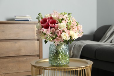 Beautiful bouquet of fresh flowers on coffee table in room