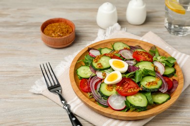 Photo of Tasty salad with vegetables and quail eggs on wooden table