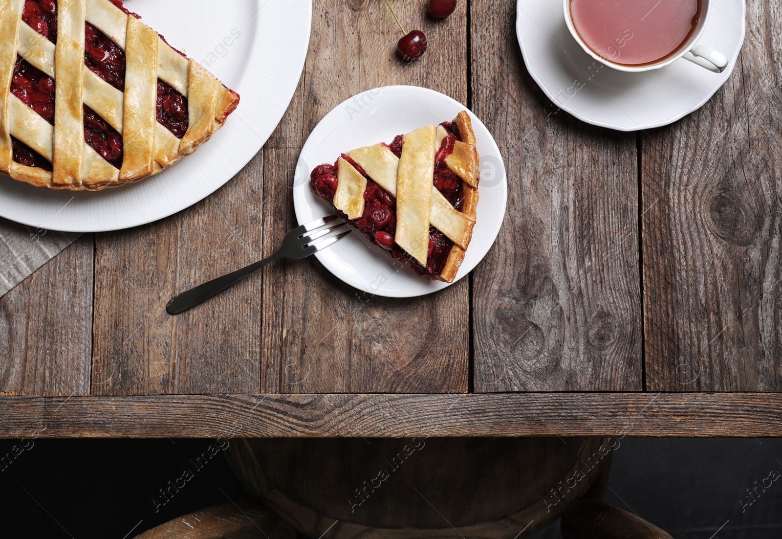 Photo of Delicious fresh cherry pie served on wooden table, flat lay