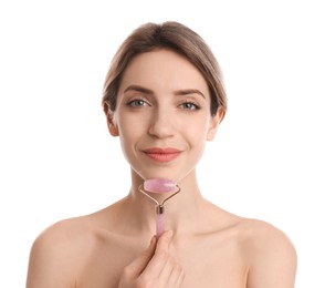 Young woman using natural rose quartz face roller on white background