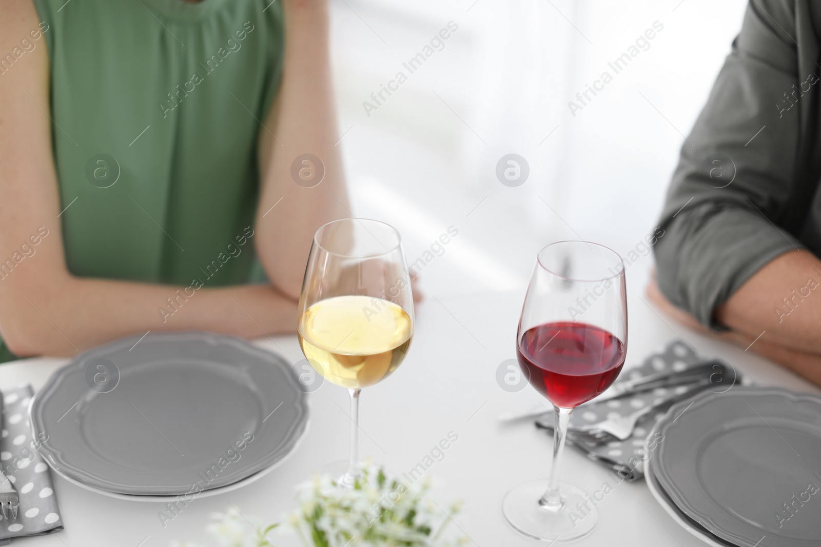 Photo of Young couple with glasses of delicious wine at table