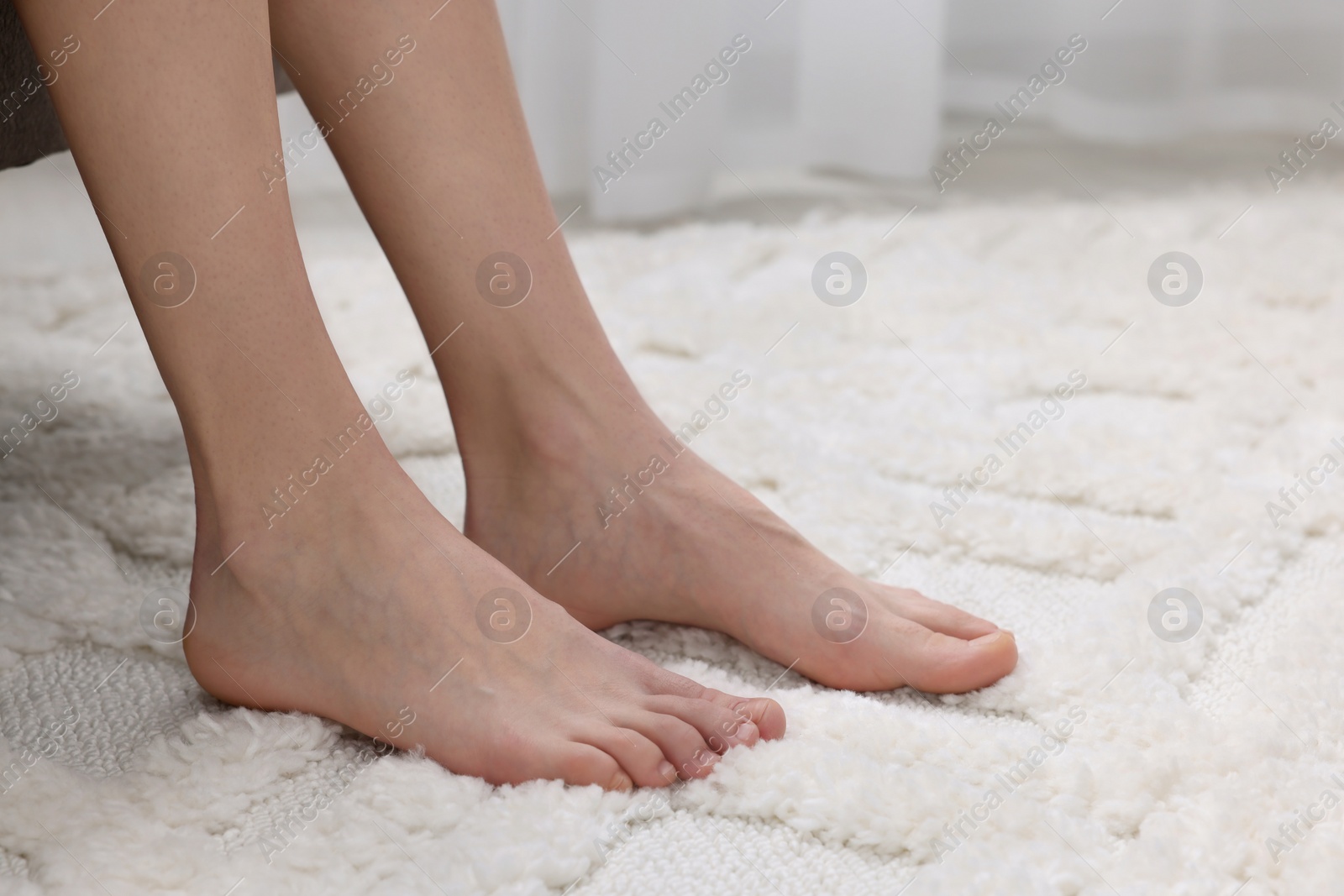 Photo of Woman on soft white carpet at home, closeup. Space for text