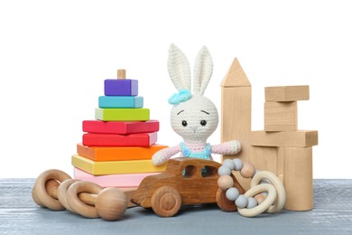 Photo of Different children's toys on grey wooden table against white background