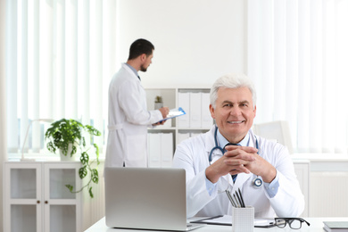 Photo of Portrait of senior doctor in white coat at workplace