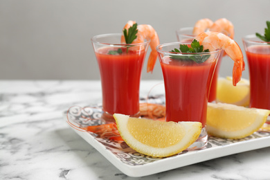 Photo of Shrimp cocktail with tomato sauce served on marble table