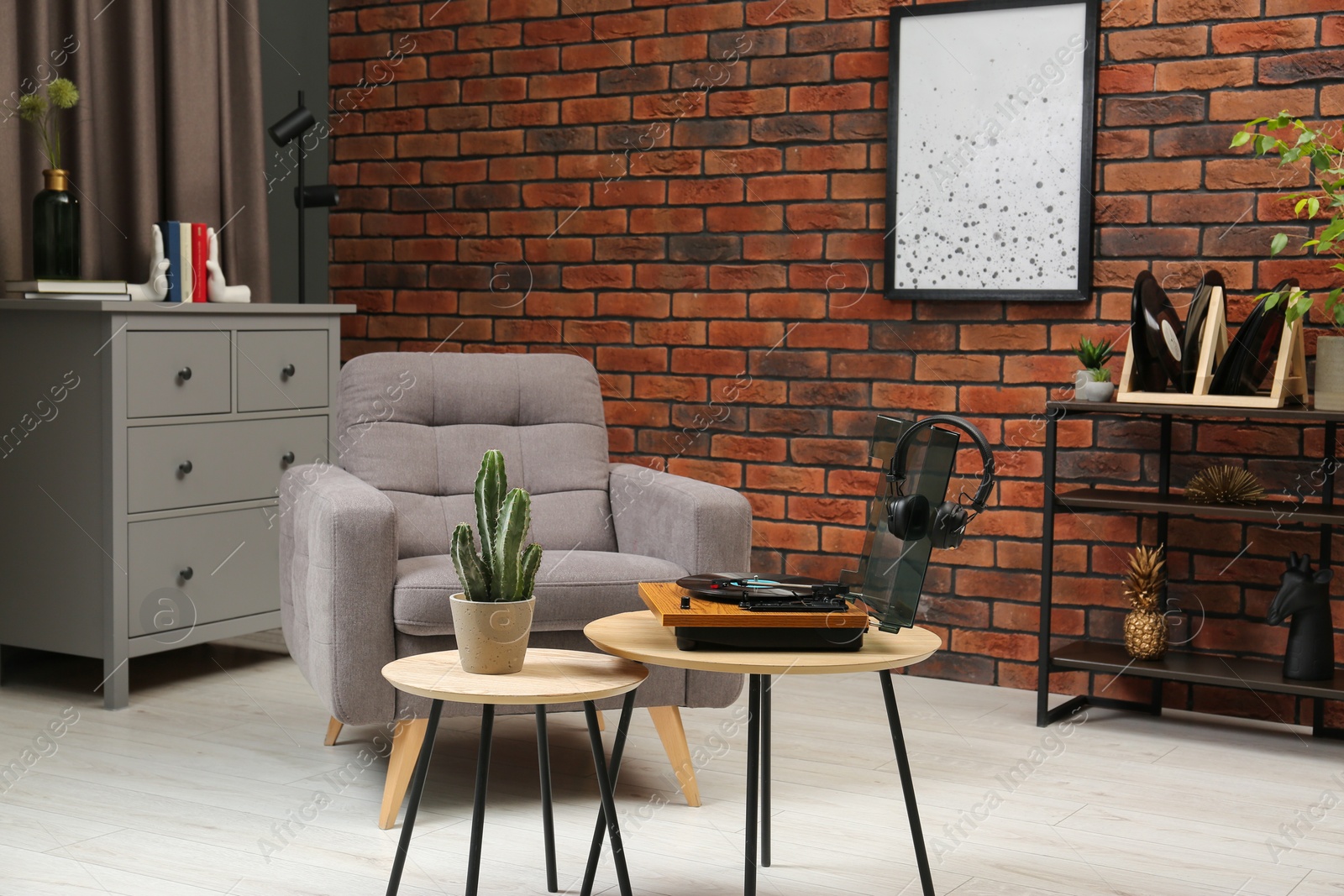 Photo of Stylish interior with modern furniture, turntable and houseplants on table indoors