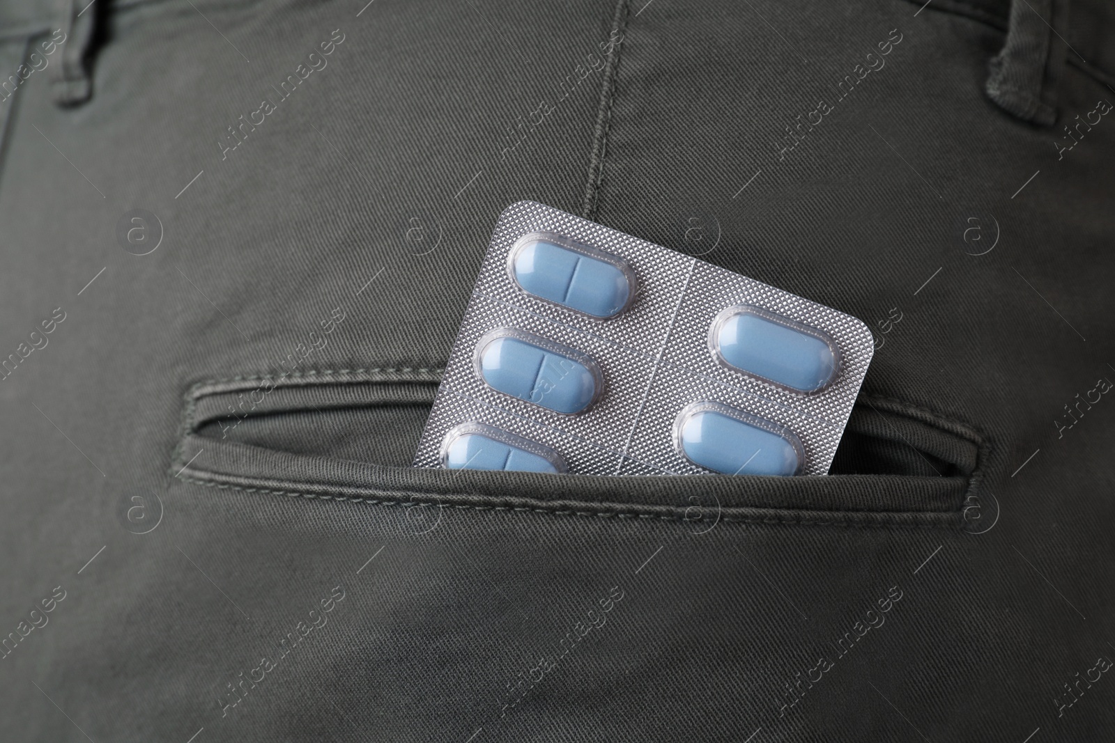 Photo of Jeans with pills in pocket, closeup. Potency problem