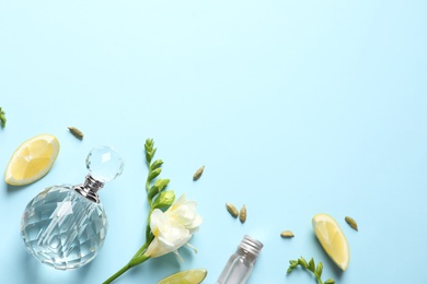 Photo of Flat lay composition with elegant perfume on light blue background, space for text