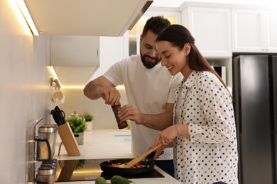 Photo of Happy lovely couple cooking together in kitchen