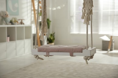 Photo of Beautiful swing in room. Stylish interior design