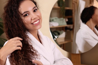 Photo of Beautiful African American woman in bathrobe at home, space for text