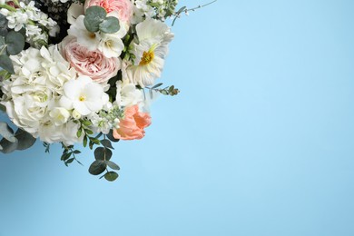 Photo of Bouquet of beautiful flowers on light blue background, top view. Space for text