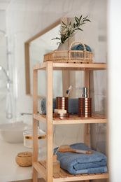 Shelving unit with toiletries in stylish bathroom interior 