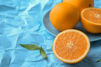 Photo of Fresh yummy oranges on color paper background