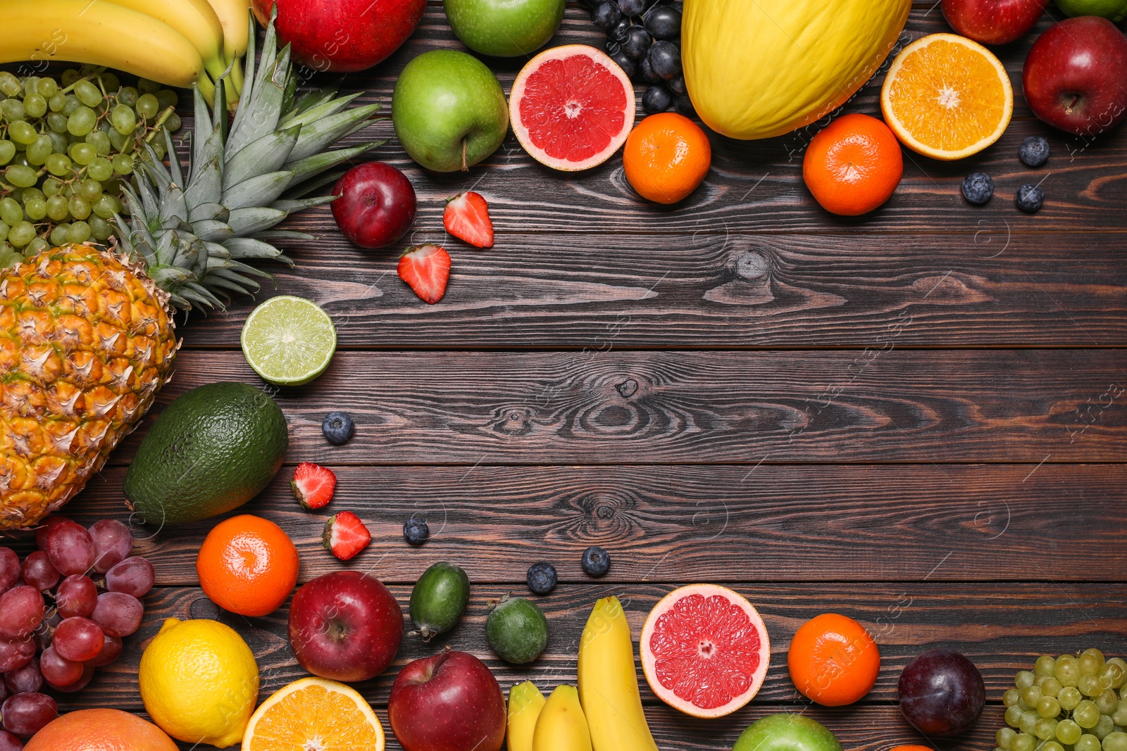 Photo of Different ripe fruits on wooden table, top view. Space for text