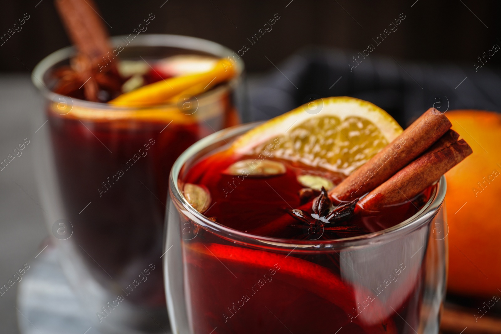 Photo of Glass of tasty mulled wine with spices, closeup