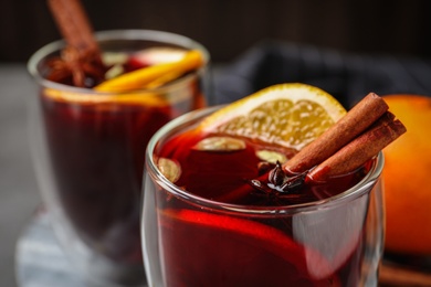 Photo of Glass of tasty mulled wine with spices, closeup