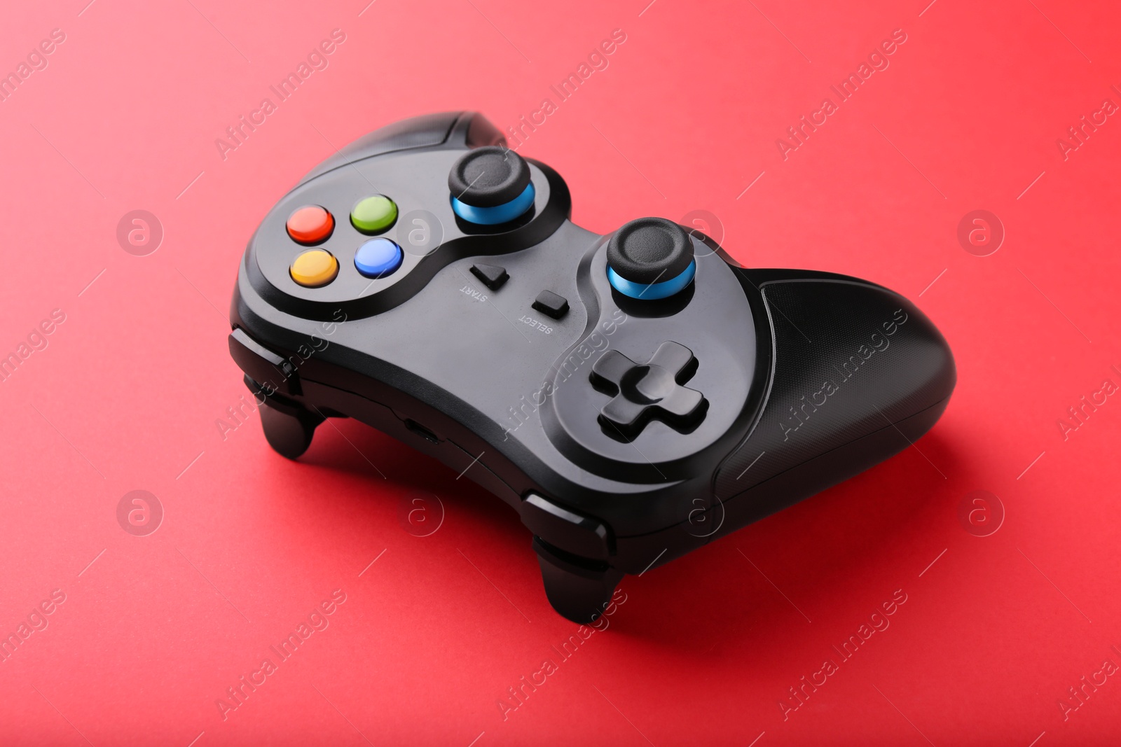 Photo of One wireless game controller on red background