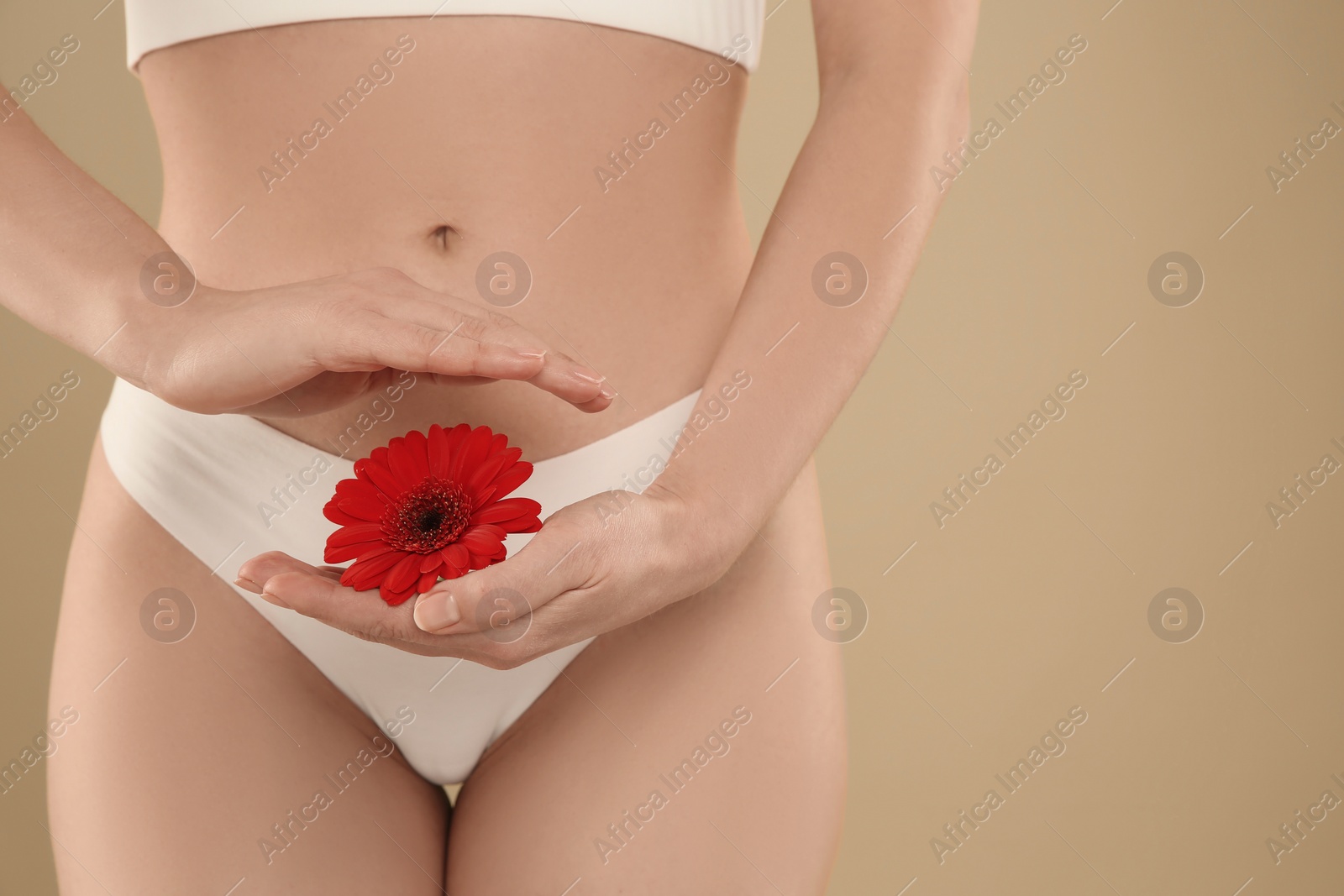 Photo of Gynecology. Woman in underwear with gerbera flower on yellow background, closeup. Space for text