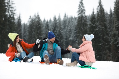 People with plastic sleds outdoors. Winter vacation