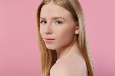 Portrait of beautiful young woman on pink background