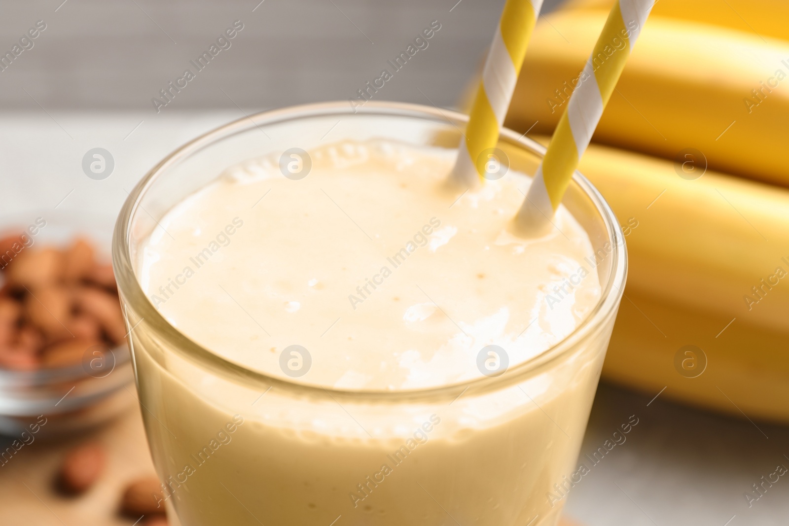 Photo of Glass with banana smoothie on table, closeup